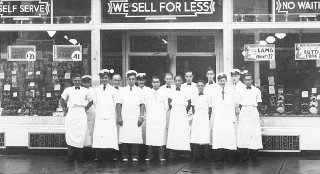 Groupe d’homme en blouse blanche devant le nouveau magasin de Loblaw.
