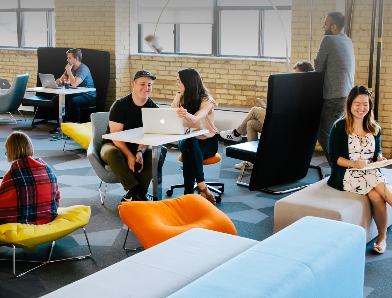 Des collègues collaborant dans un bureau ouvert et coloré.