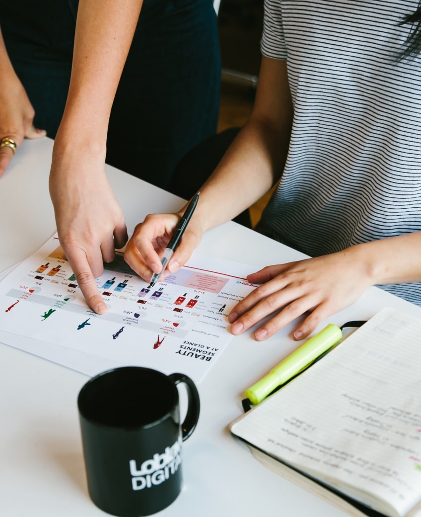 Close up of two employees hands working on a project together.