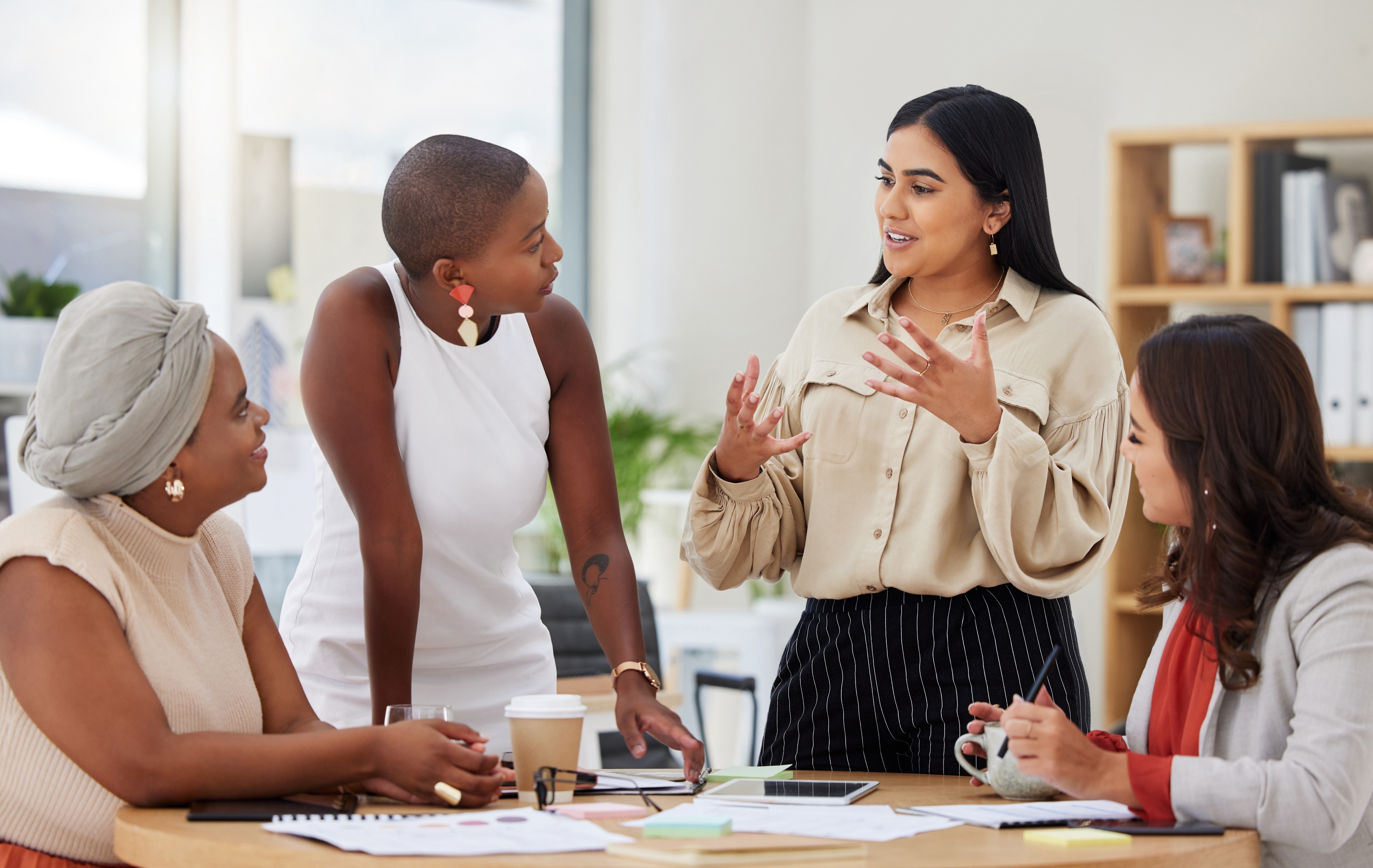 Quatre femmes d’origines différentes discutent. Elles sont réunies autour d’une table dans un bureau.