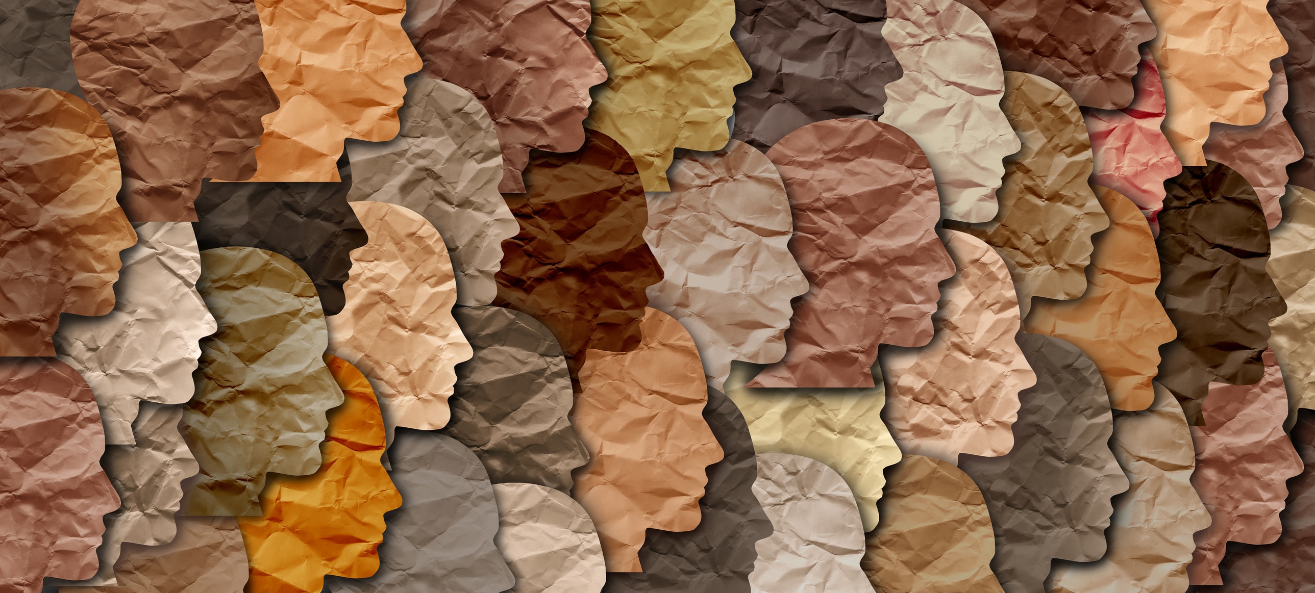 Plusieurs silhouettes en papier, en forme de visage, sont superposées. Elles sont de différentes couleurs, pour représenter la diversité.