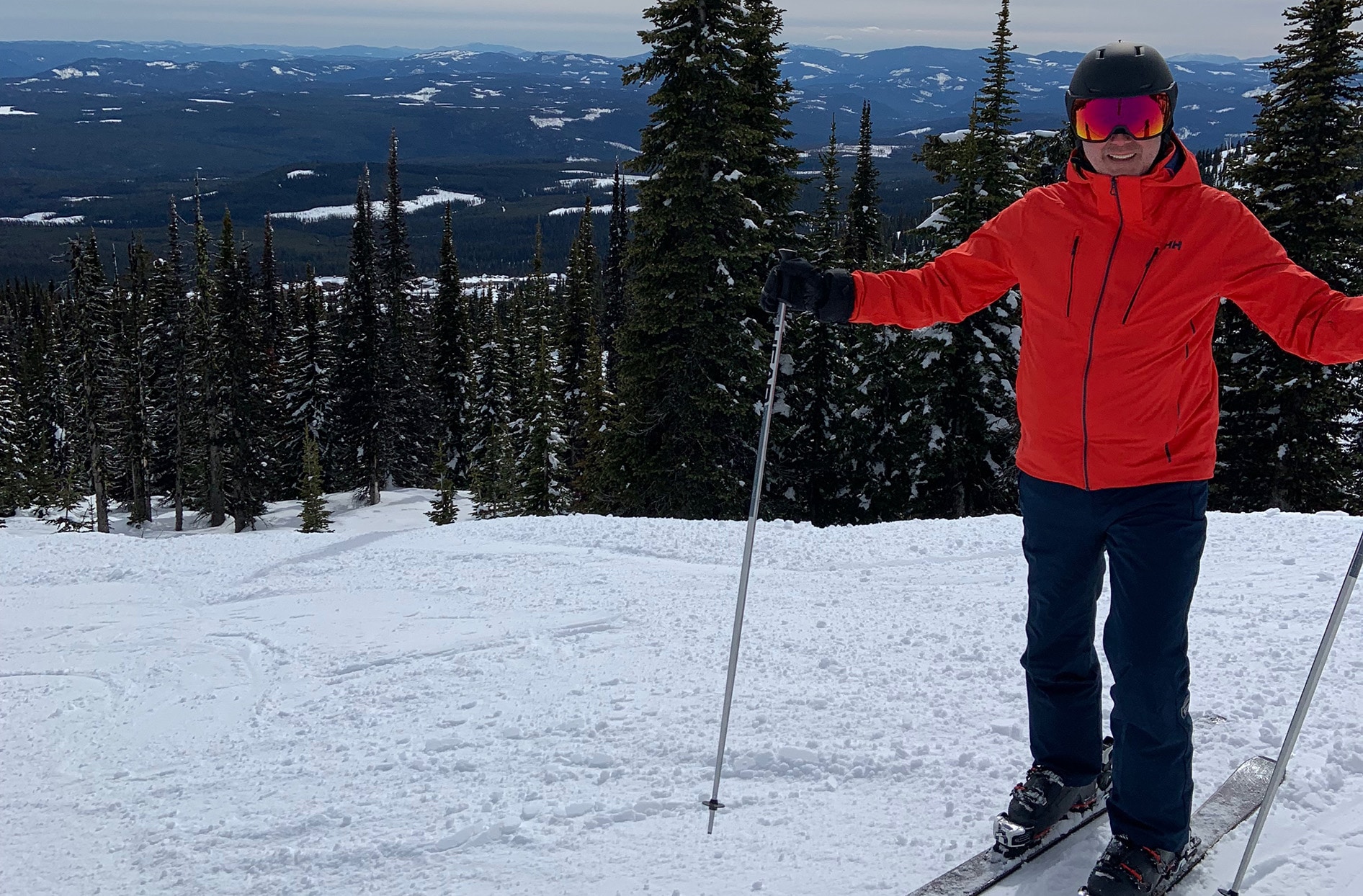 Andy se tient sur une colline de ski enneigée et porte tout son équipement de ski.