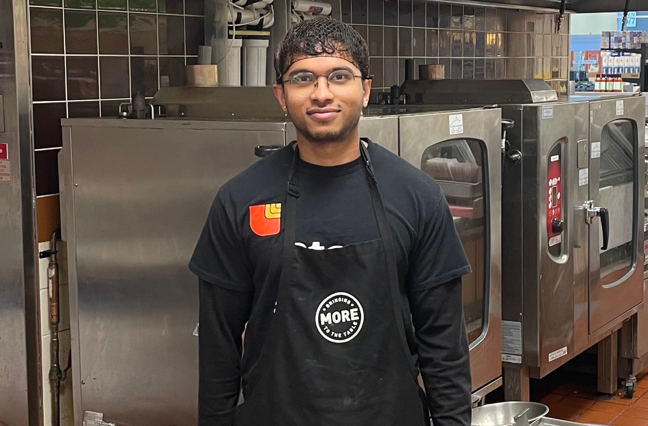 Young man working in deli department of grocery store