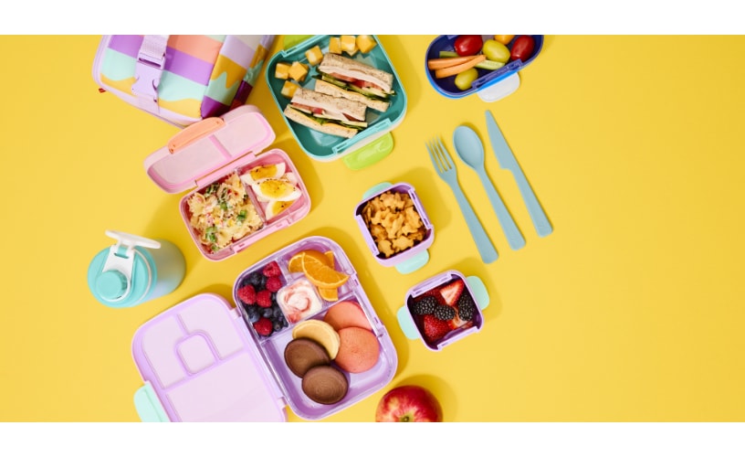 An aerial photo of colourful back to school products including snack boxes and water bottles. 