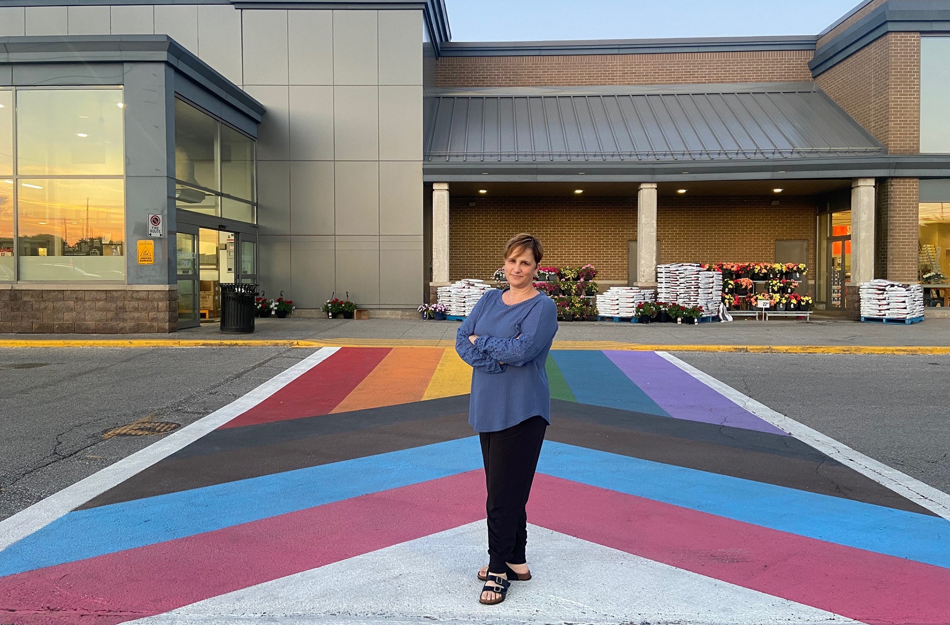 Brenda à l’extérieur de son magasin, sur le passage pour piétons arc-en-ciel.