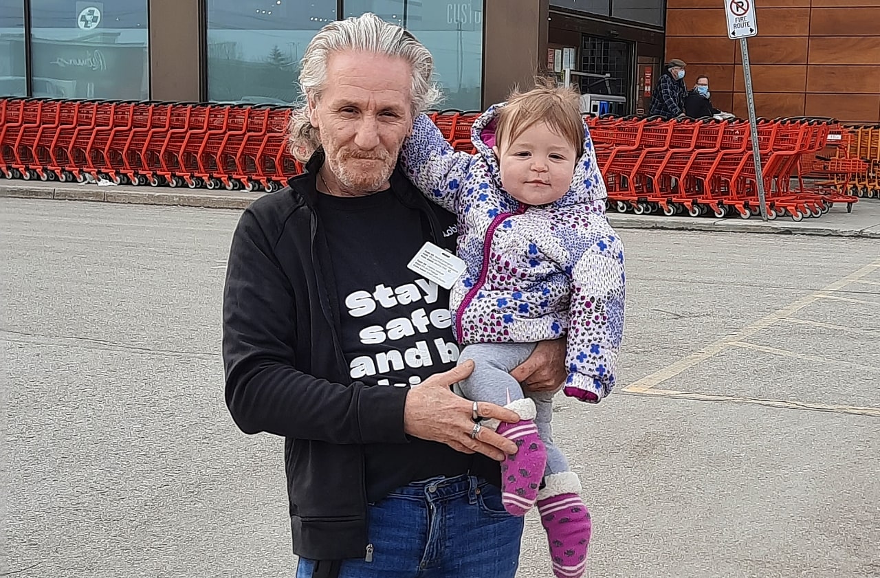 Man holding baby girl outside of store 