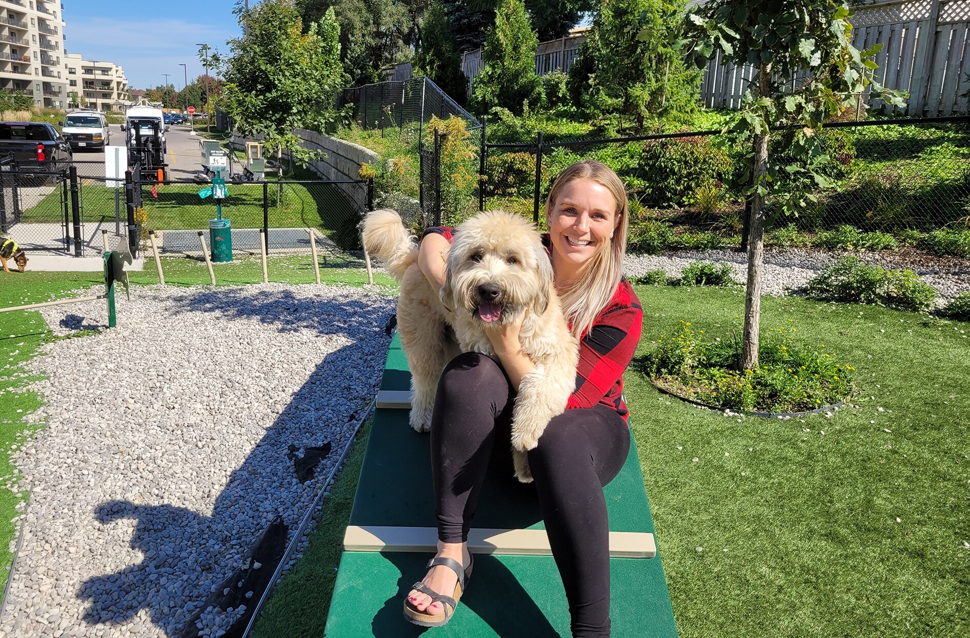 Caylyn s’assoit à l’extérieur sur une table avec son chien sur les genoux.