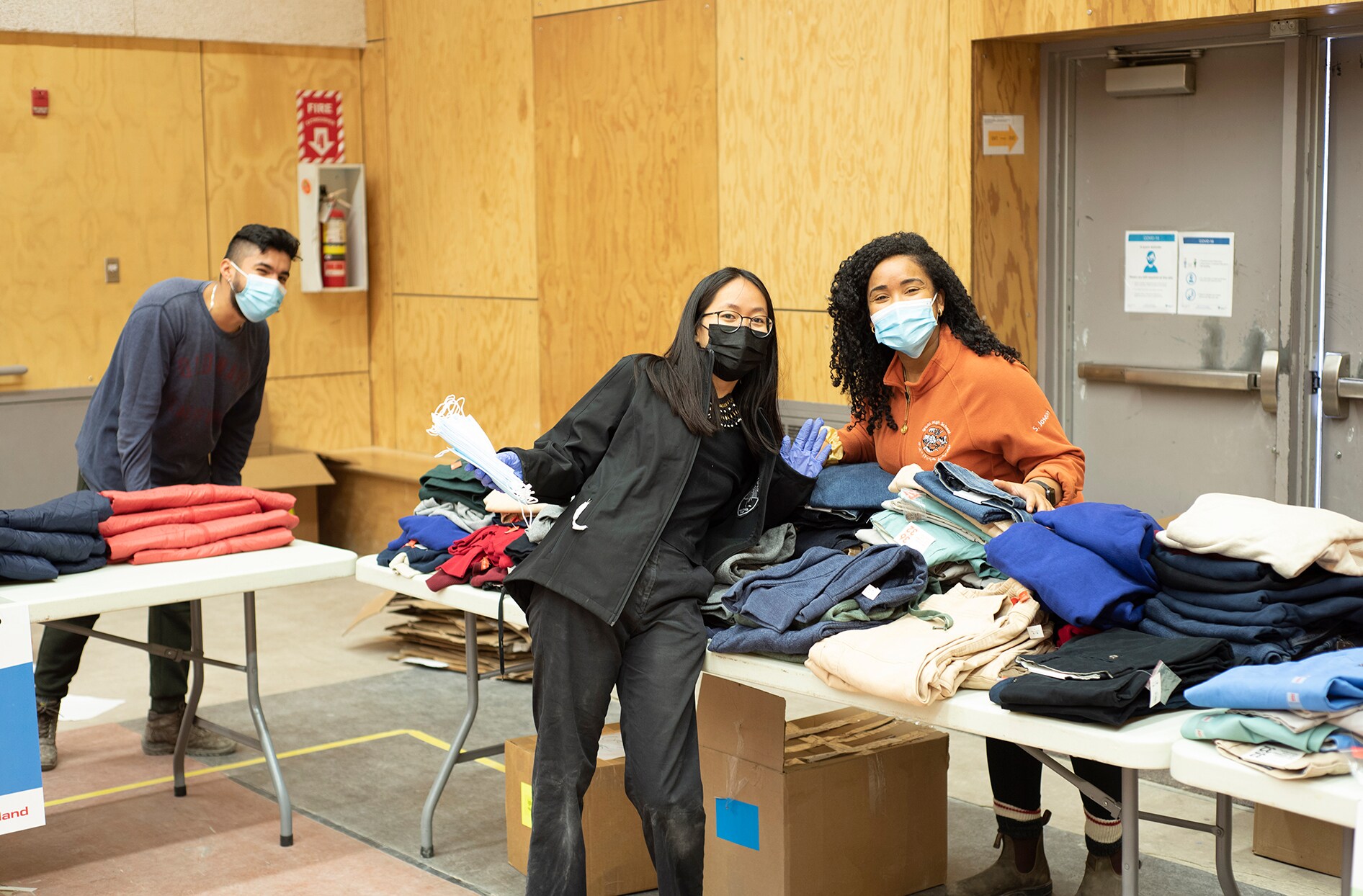 Colleen stands in front of a table with Joe Fresh merchandise and a volunteer.