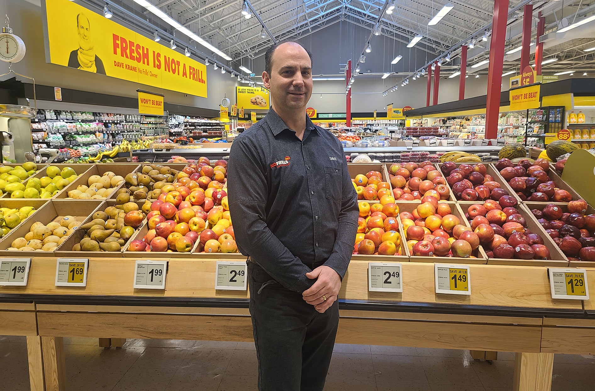 Dave stands inside his store with produce in the background.