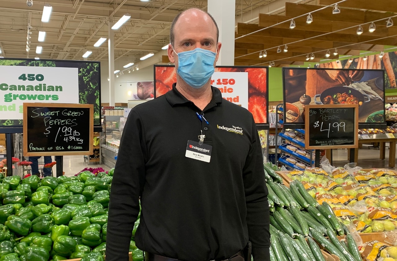 Man standing in grocery store produce department