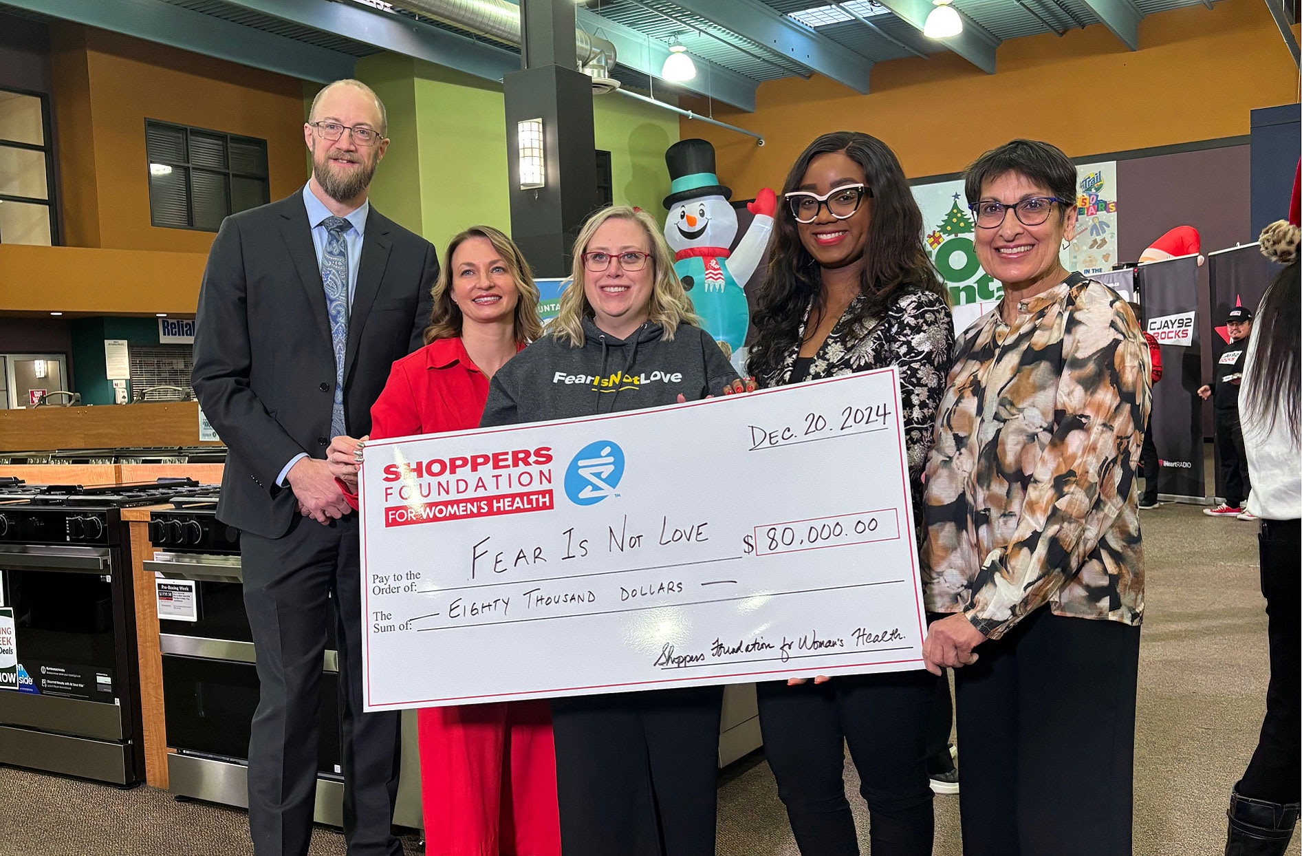 A group of employees holding a cheque in their hands.