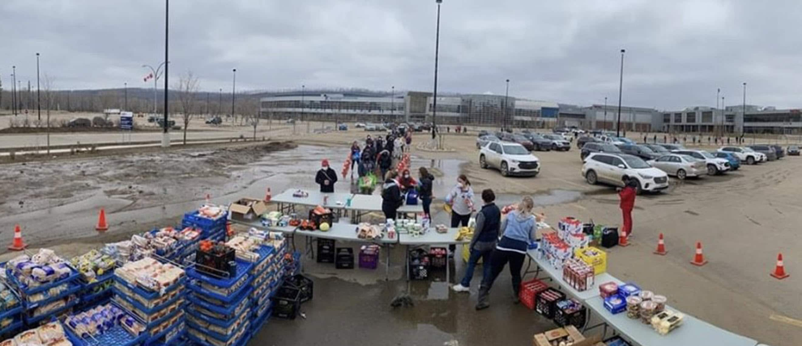 People who have been evacuated due to flooding line up for food