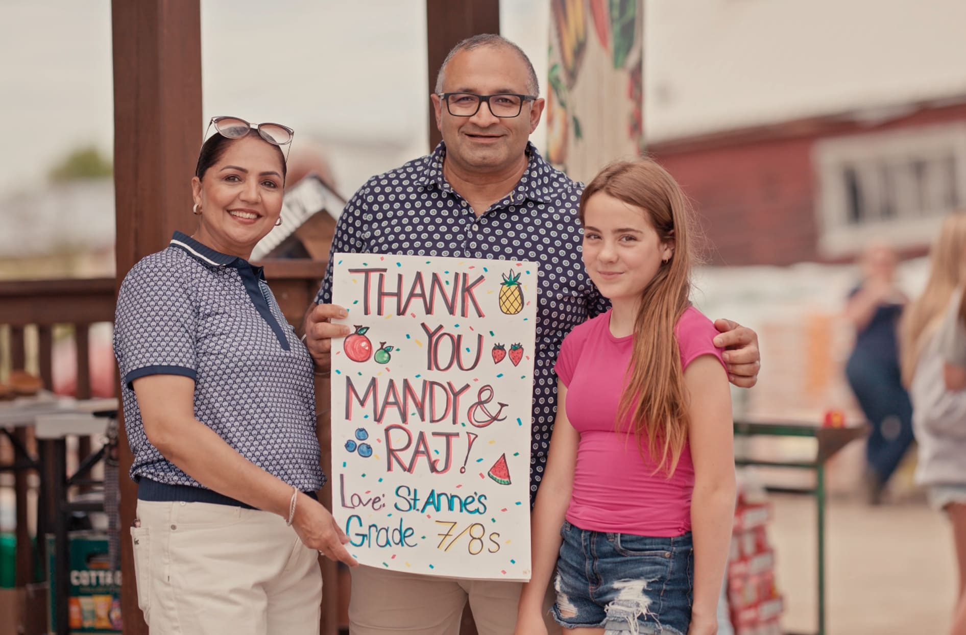 Your Independent Grocer Iroquois Falls store owners Mandy Toor and Raj Sharma posing proudly with a local student at one of their fundraising events. Mandy and Raj are holding a poster that the students made that says ‘thank you Mandy and Raj, love St. Ann