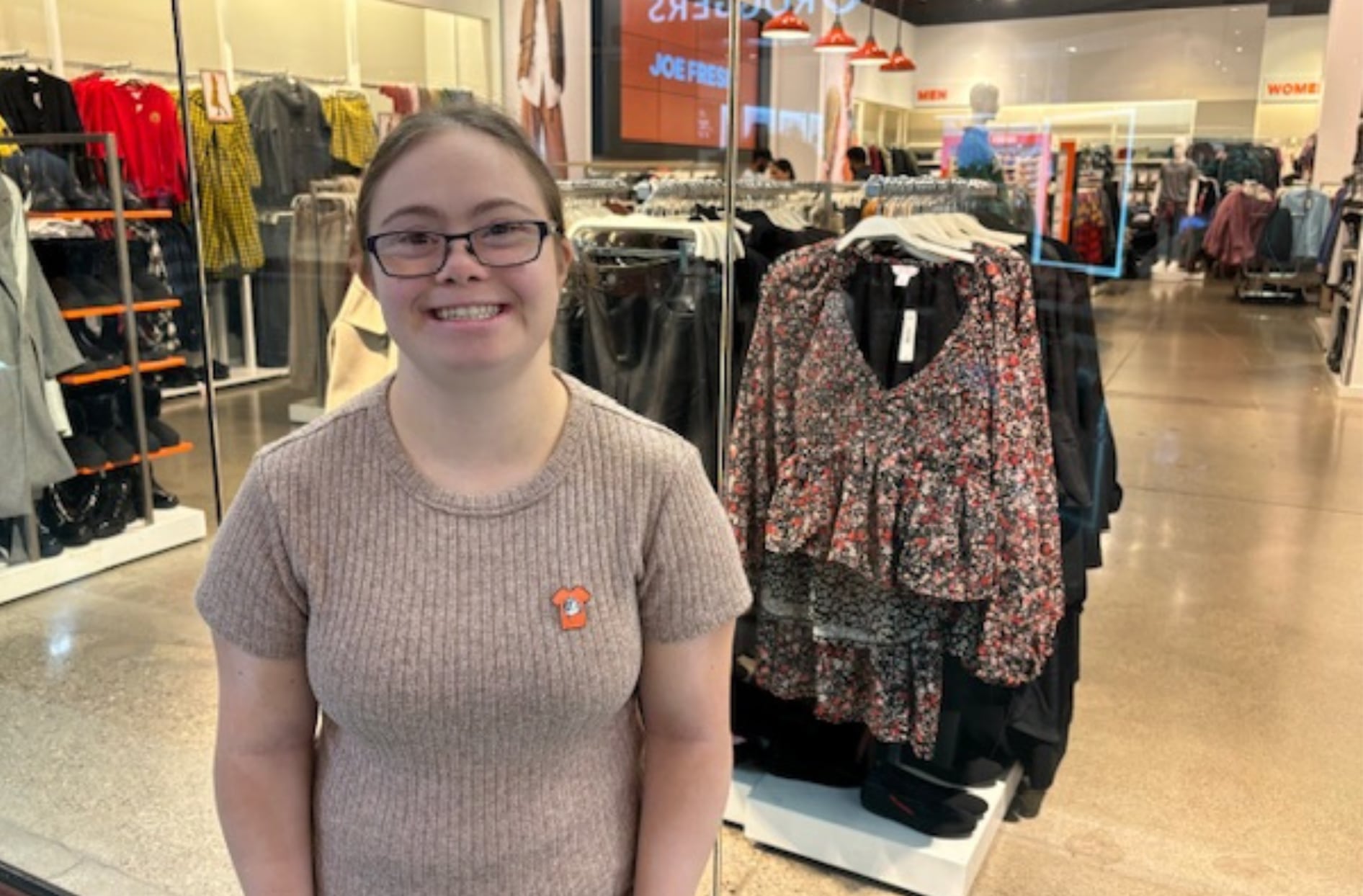 Jasmine stands in front of her Joe Fresh store, smiling.