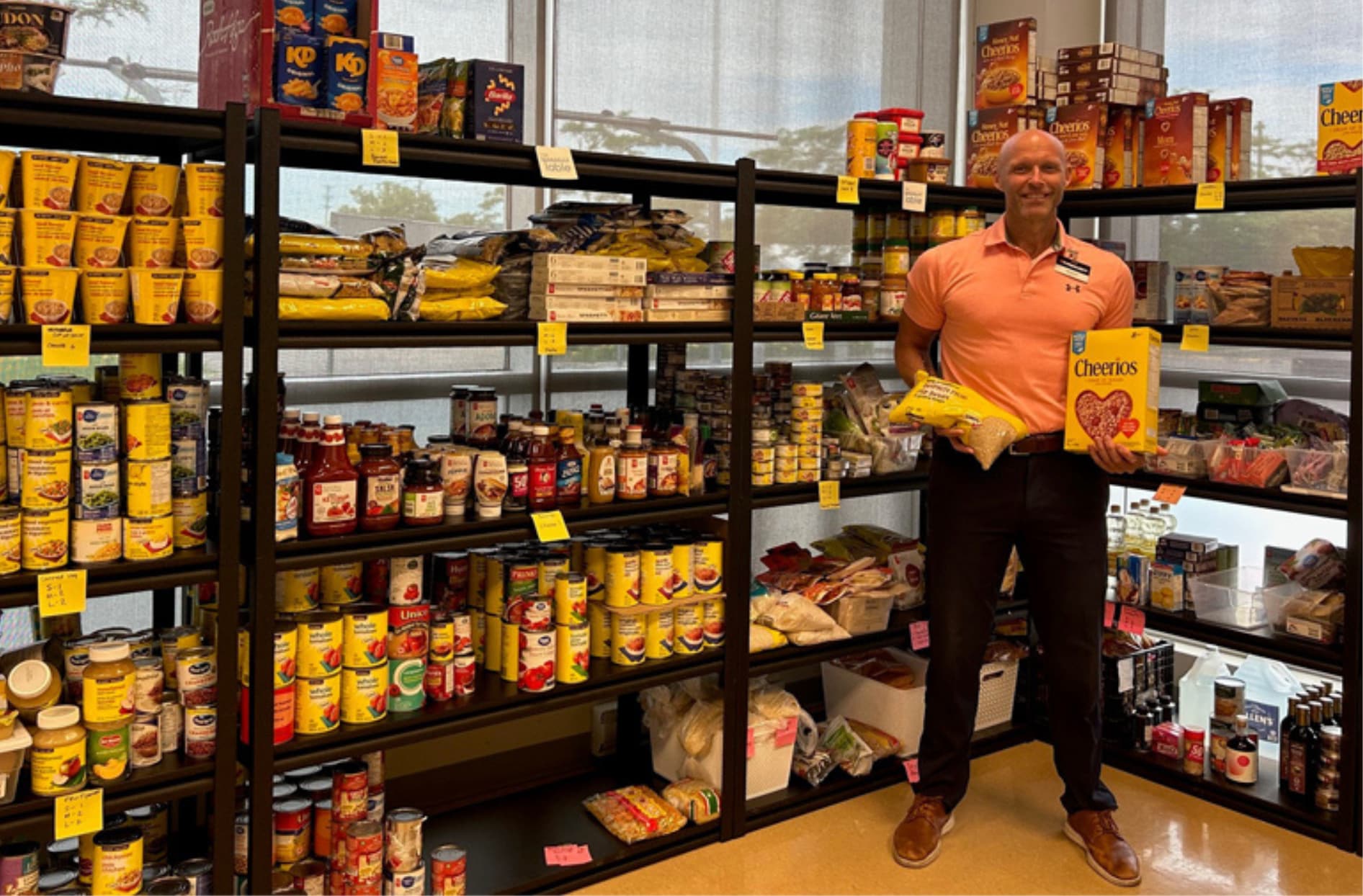 Jeff Brierley, propriétaire d’un magasin Your Independant GrocerMD, pose fièrement avec les produits offerts à la banque alimentaire Community Table de Riverside South, qui est organisée dans son magasin.  
