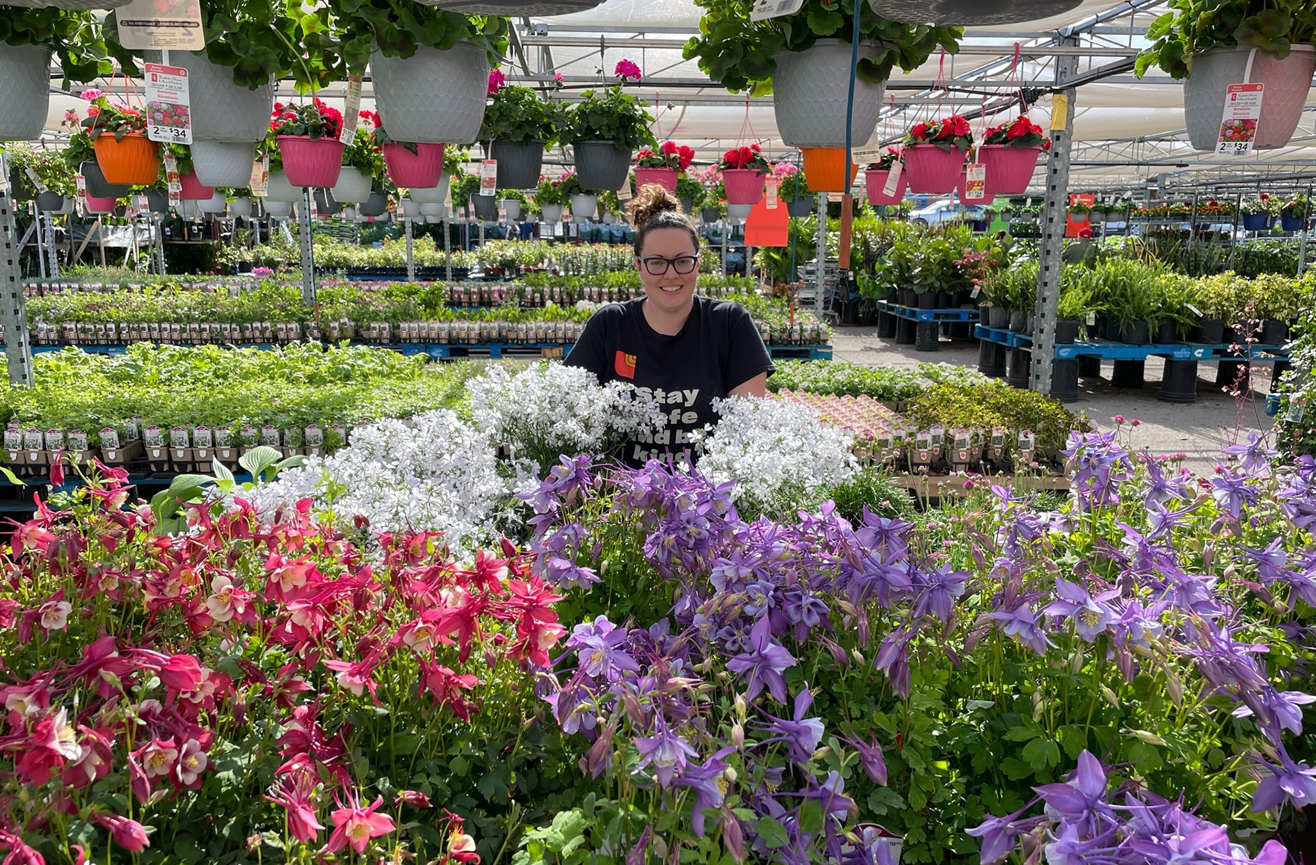 Jennifer sits behind a display of different flowers and plants in the garden centre at Loblaws.  