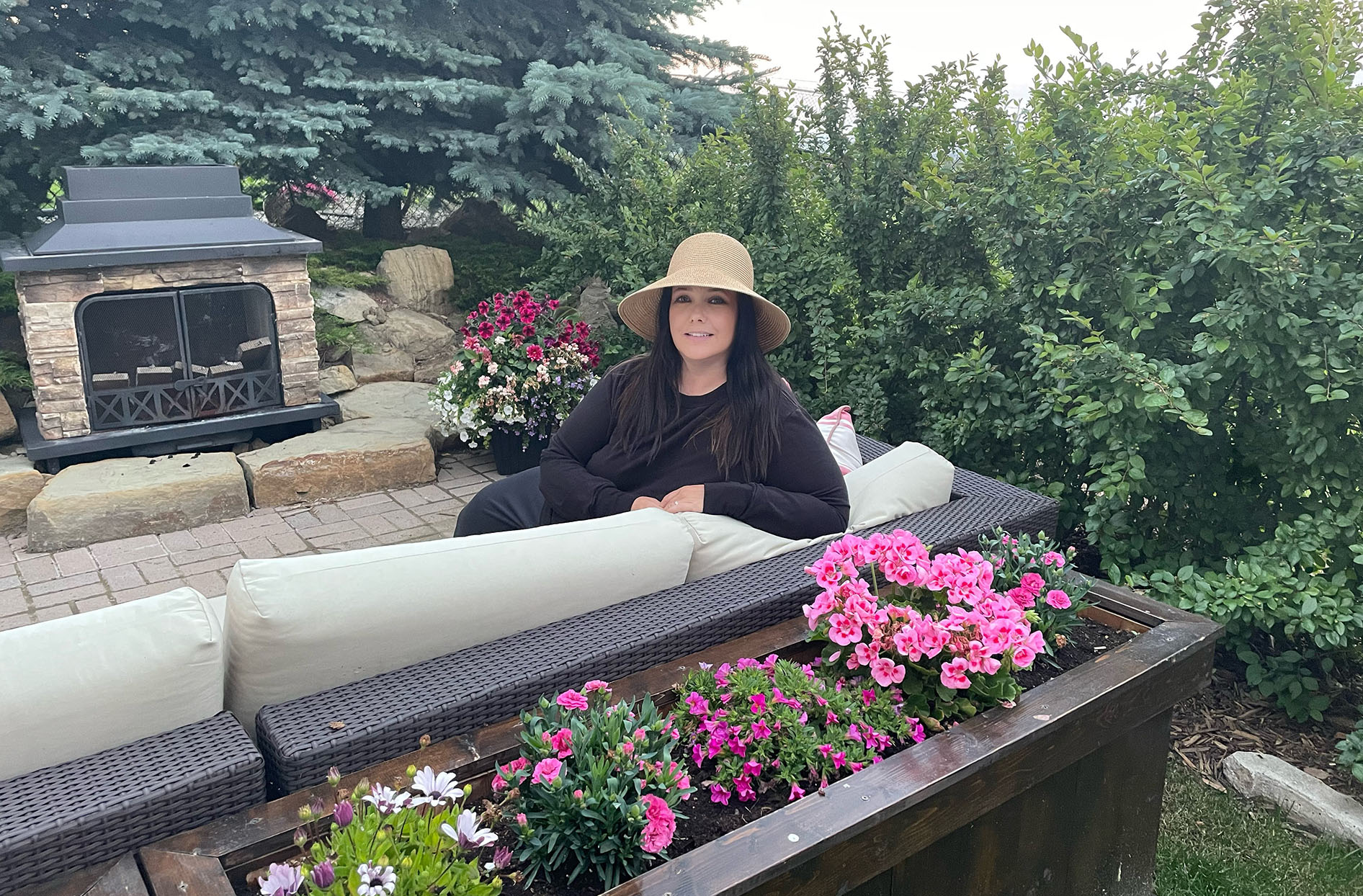 Jody sits outside in her backyard on the couch. 