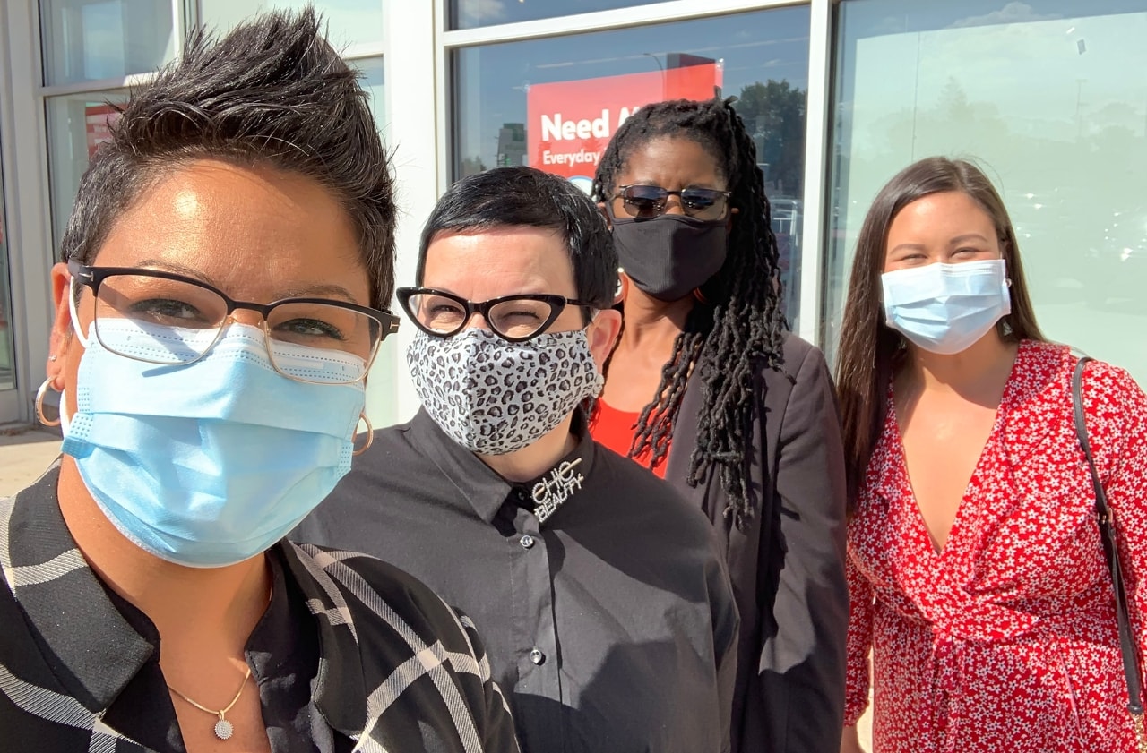 Four people standing outside store 