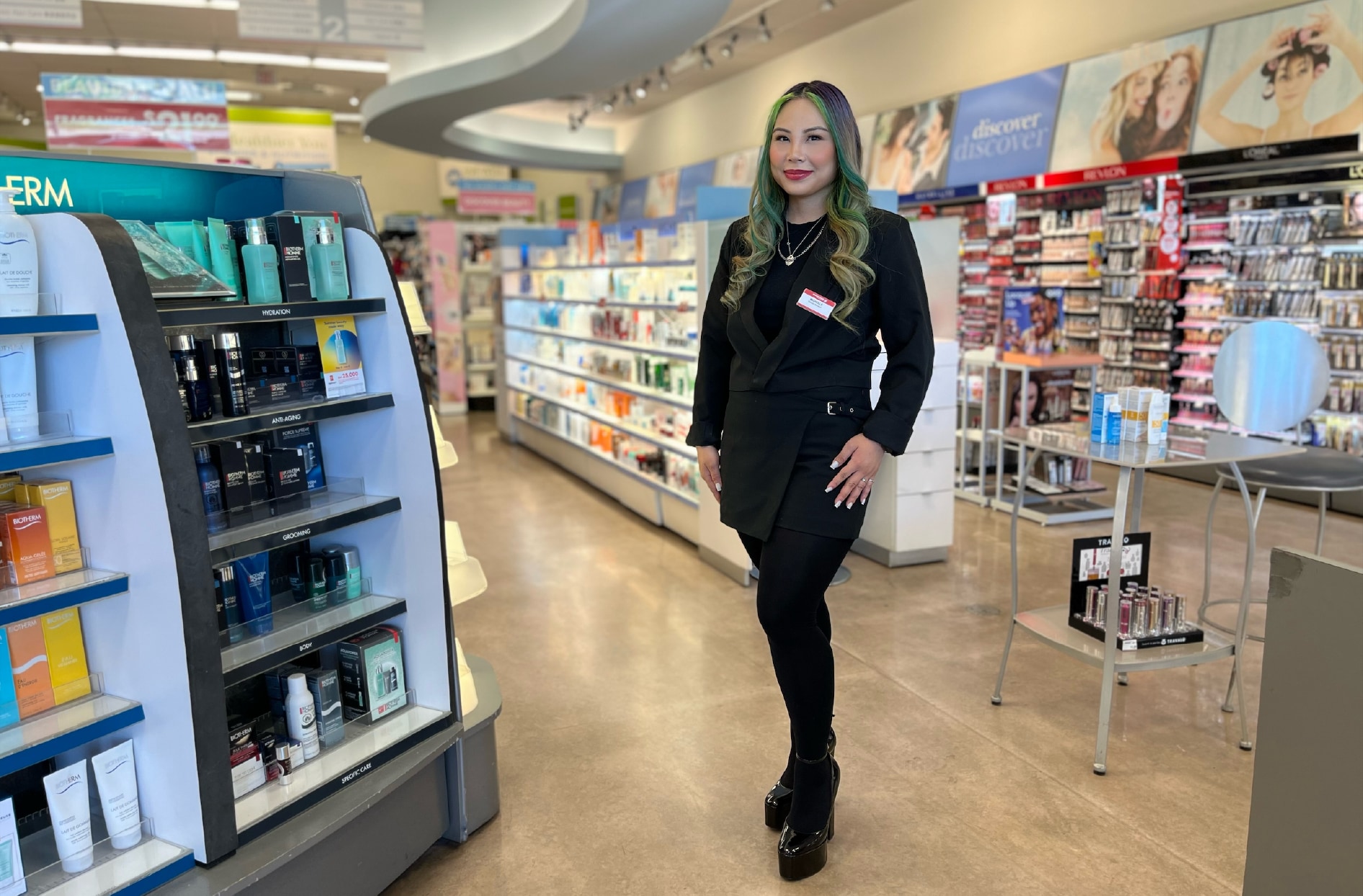 Michelle stands, smiling, inside her Shoppers Drug Mart location store.  