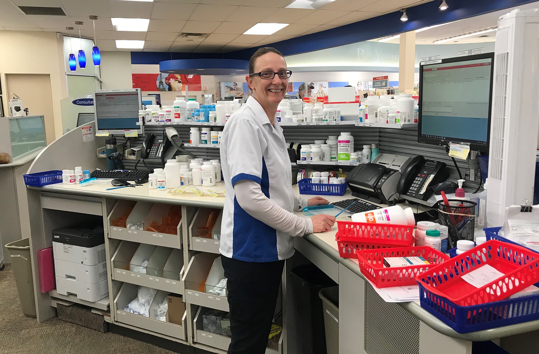 Misty stands behind the pharmacy counter inside her store.