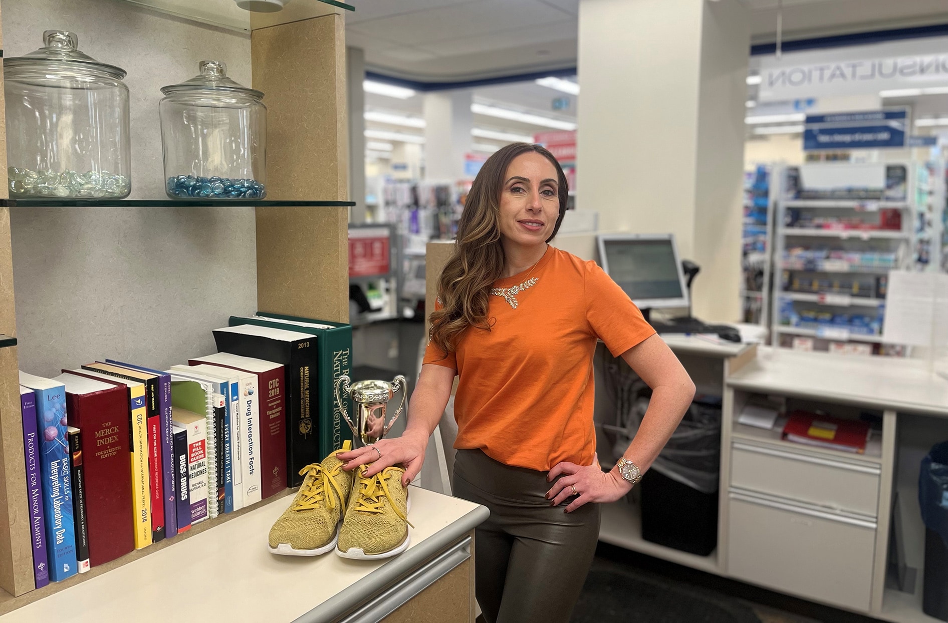 Nadine stands inside her store with her hands on a pair of sneakers