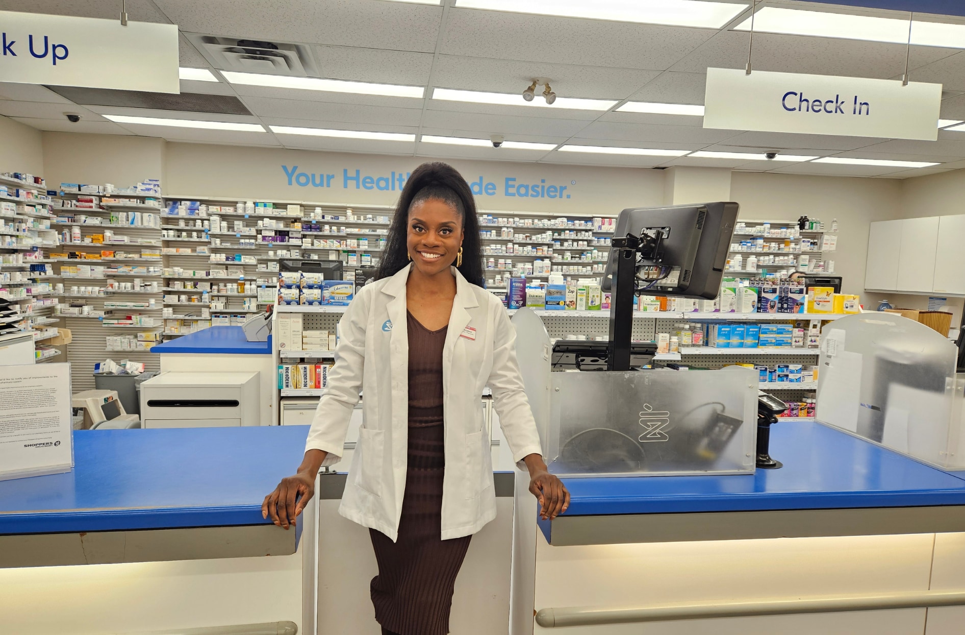 Nneka, souriante, debout dans l’une de ses pharmacies. 