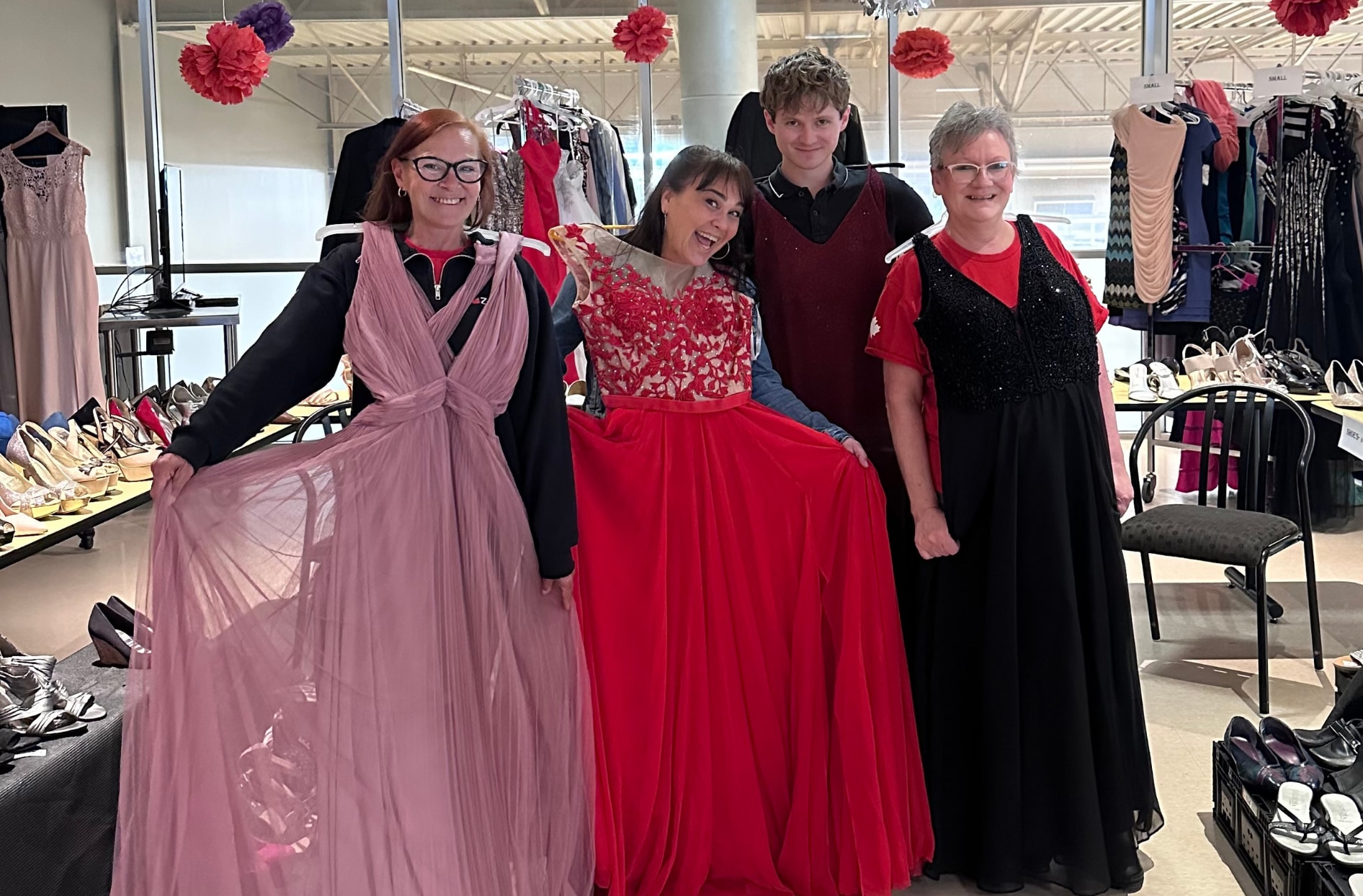A group of Zehrs colleagues hold up some of the prom dresses that were available for donation.