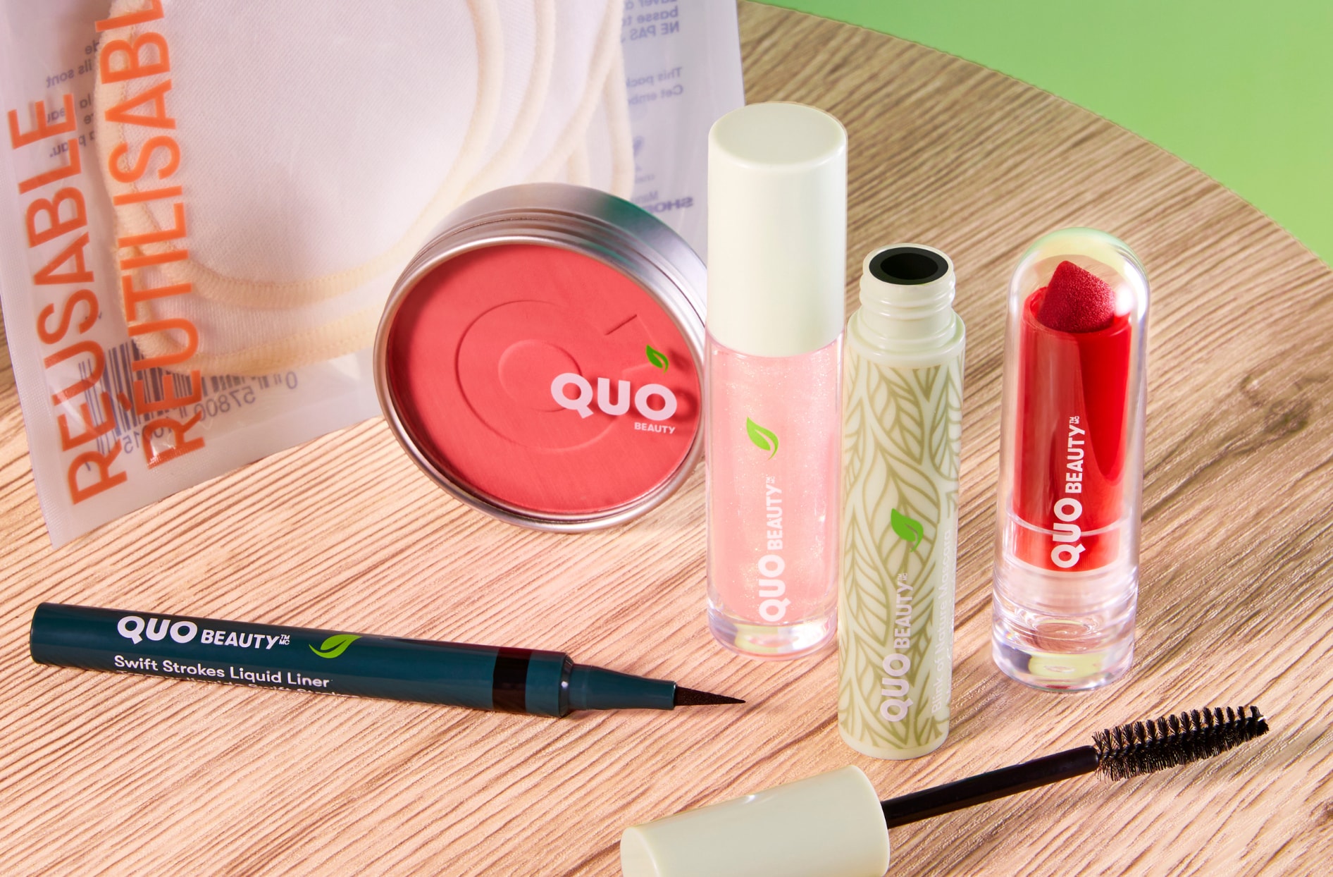 Une photo de la nouvelle collection « Pour l’amour de notre planète » de Quo Beauty montrant un pinceau à mascara, un rouge à lèvres, un fard à joues et un ligneur. 