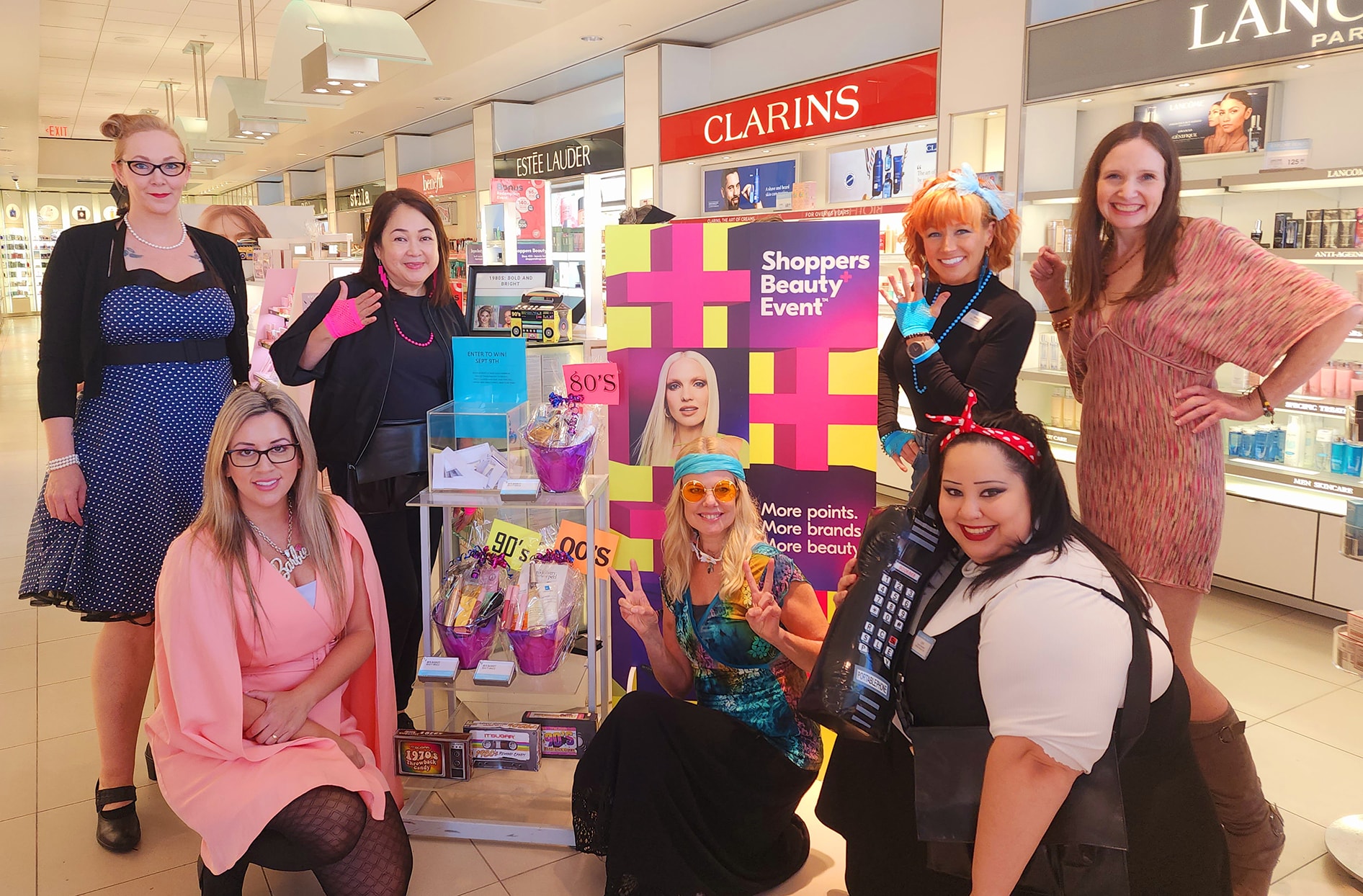 Shenaz and employees smile inside their store’s beauty section. 