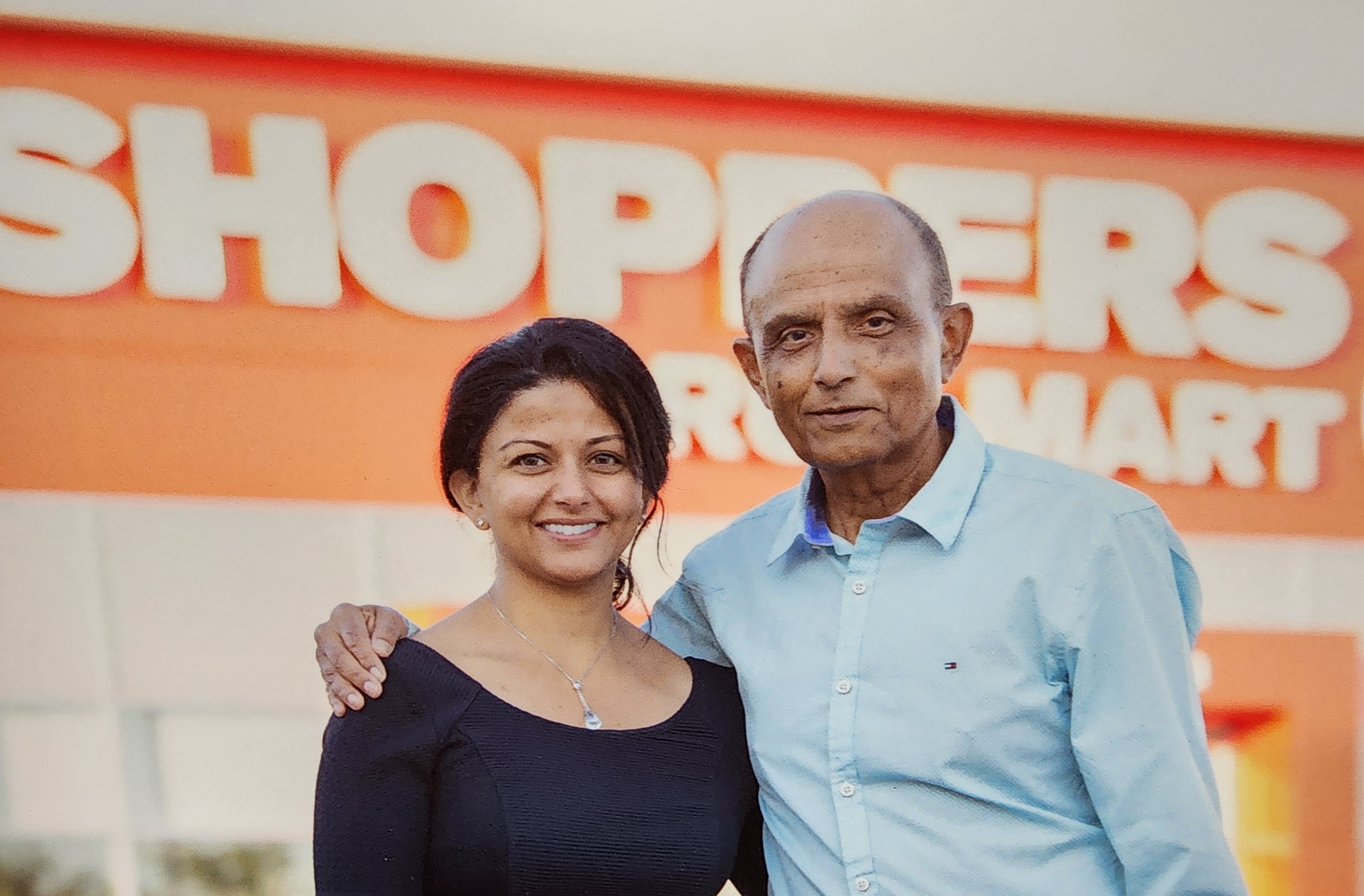 Une photo de Sonal et de Bachu, souriants, debout dans la pharmacie. 