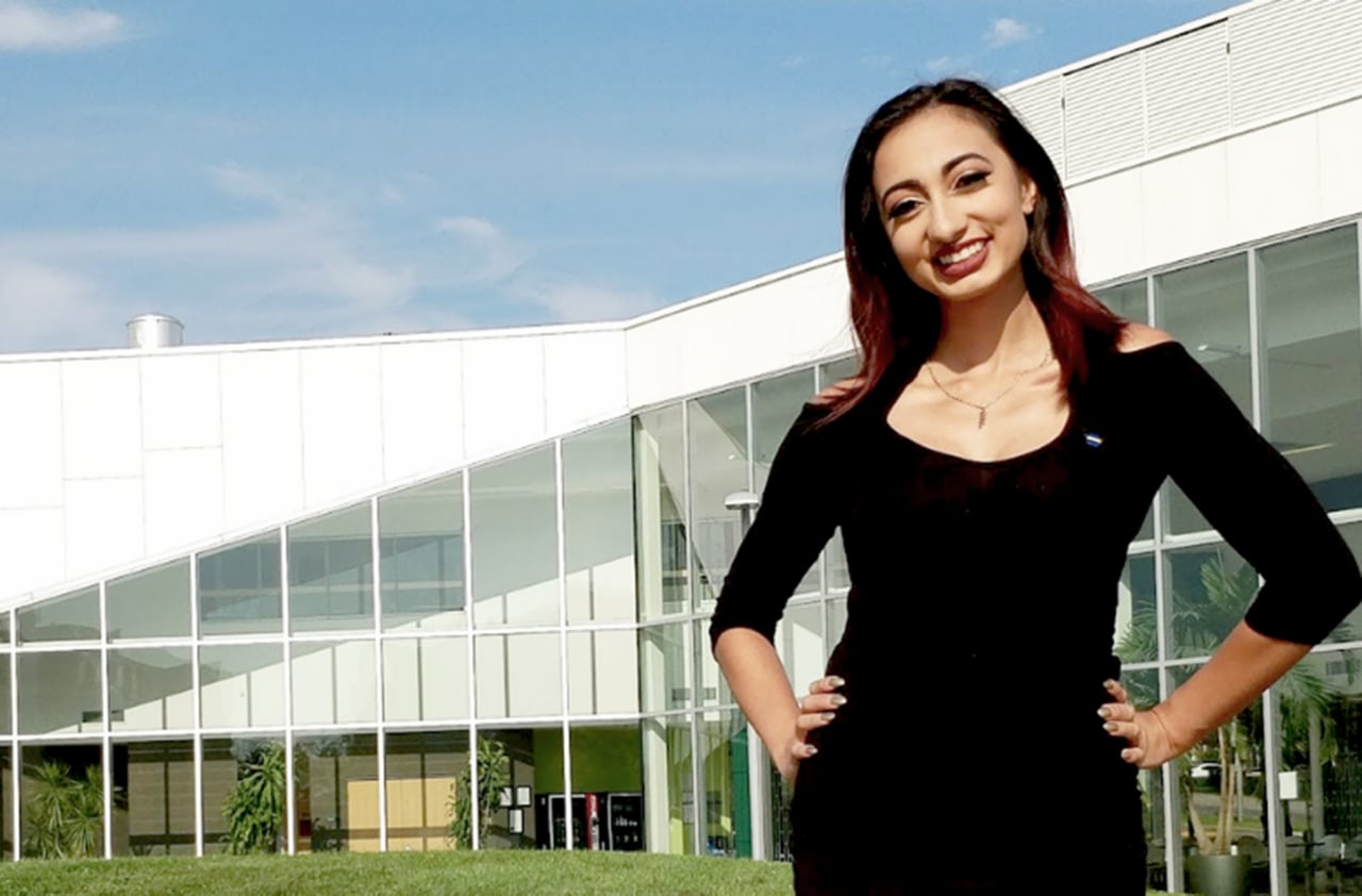 Woman standing with hands on hips in front of school campus 