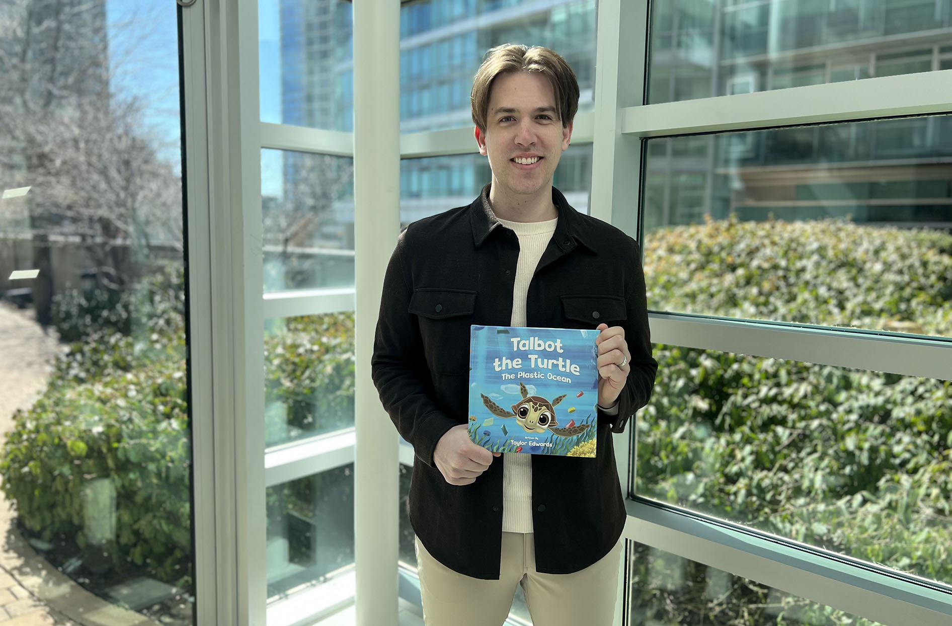 Taylor stands while holding his book.  