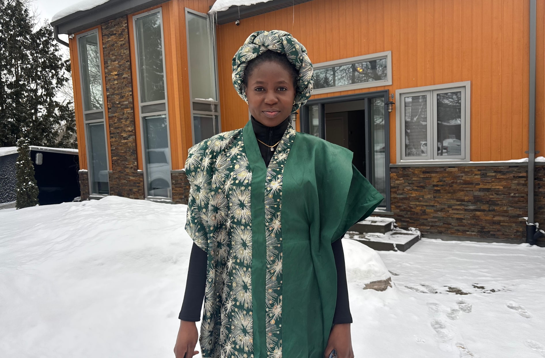 Christiana standing outside in the snow wearing traditional Nigerian clothing.  