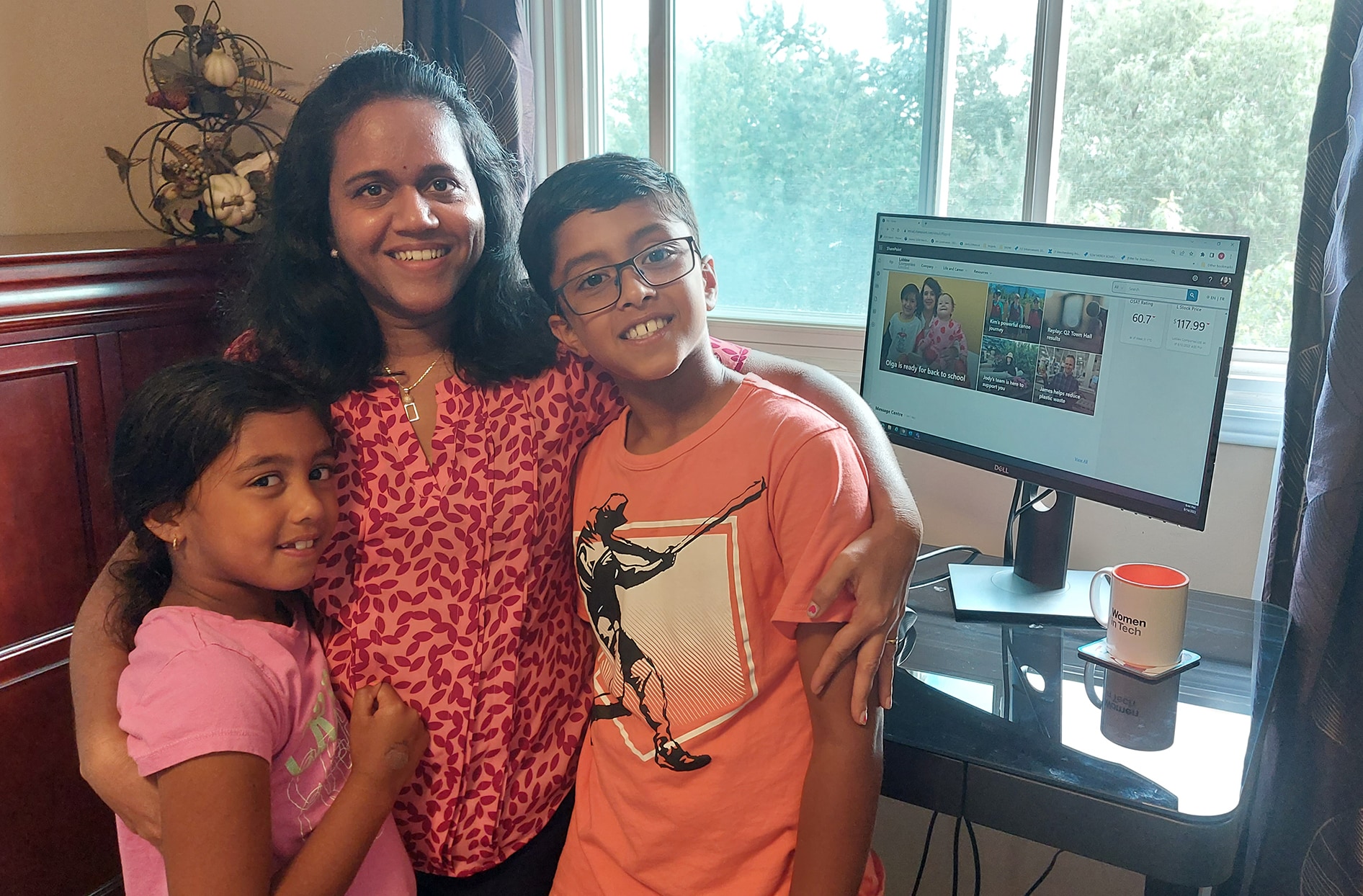 Vidya est assise avec ses deux enfants dans son bureau à domicile.