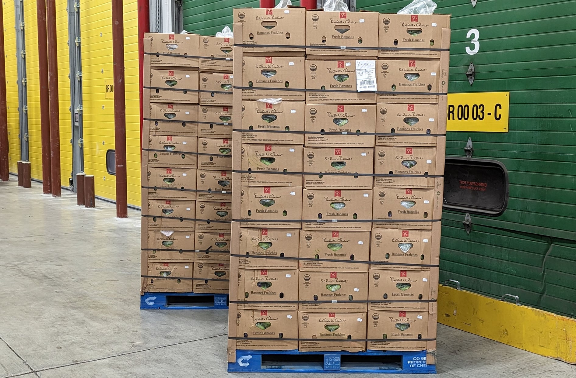 Une photo de deux palettes de bananes montrant les planches cornières en carton utilisées sur les boîtes de bananes. 