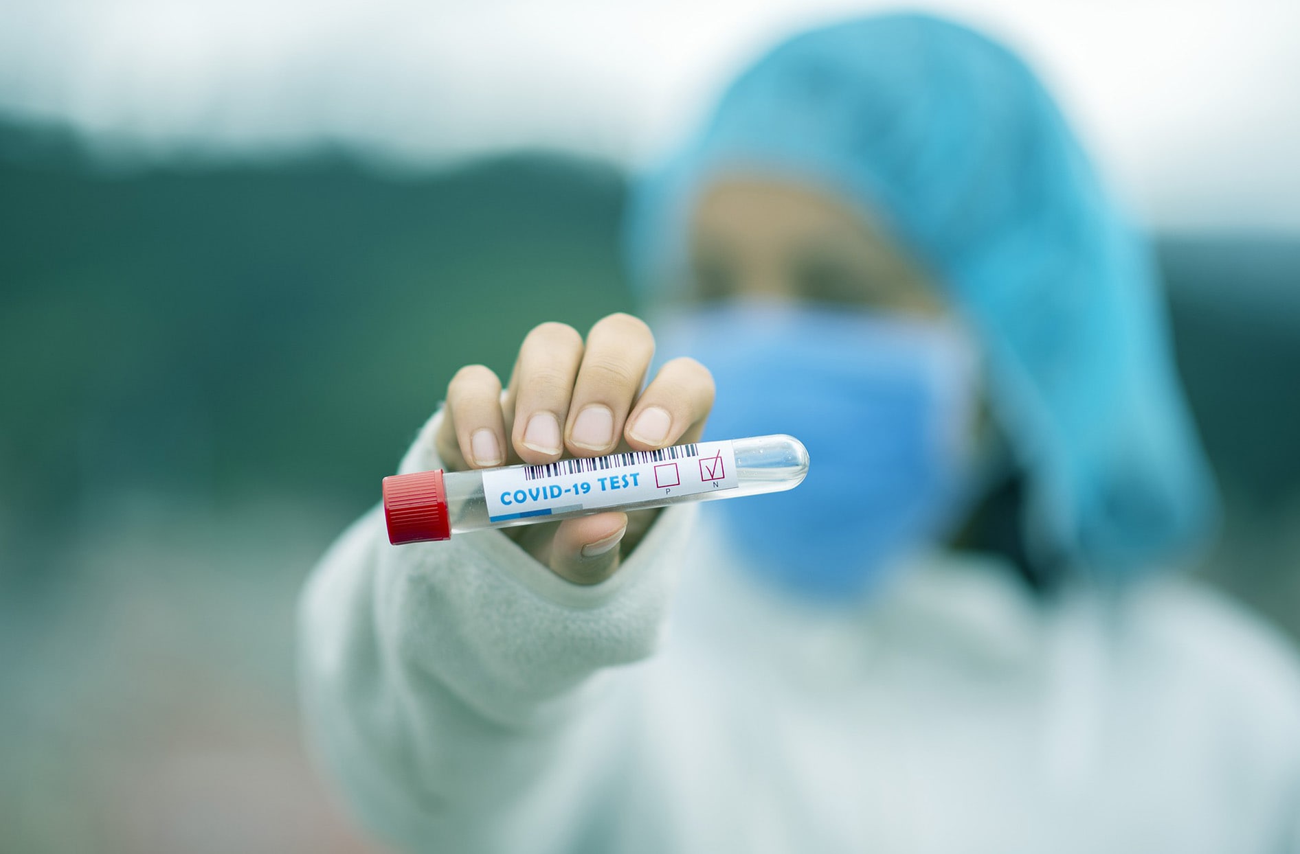 A healthcare worker holds a COVID-19 test vial. 