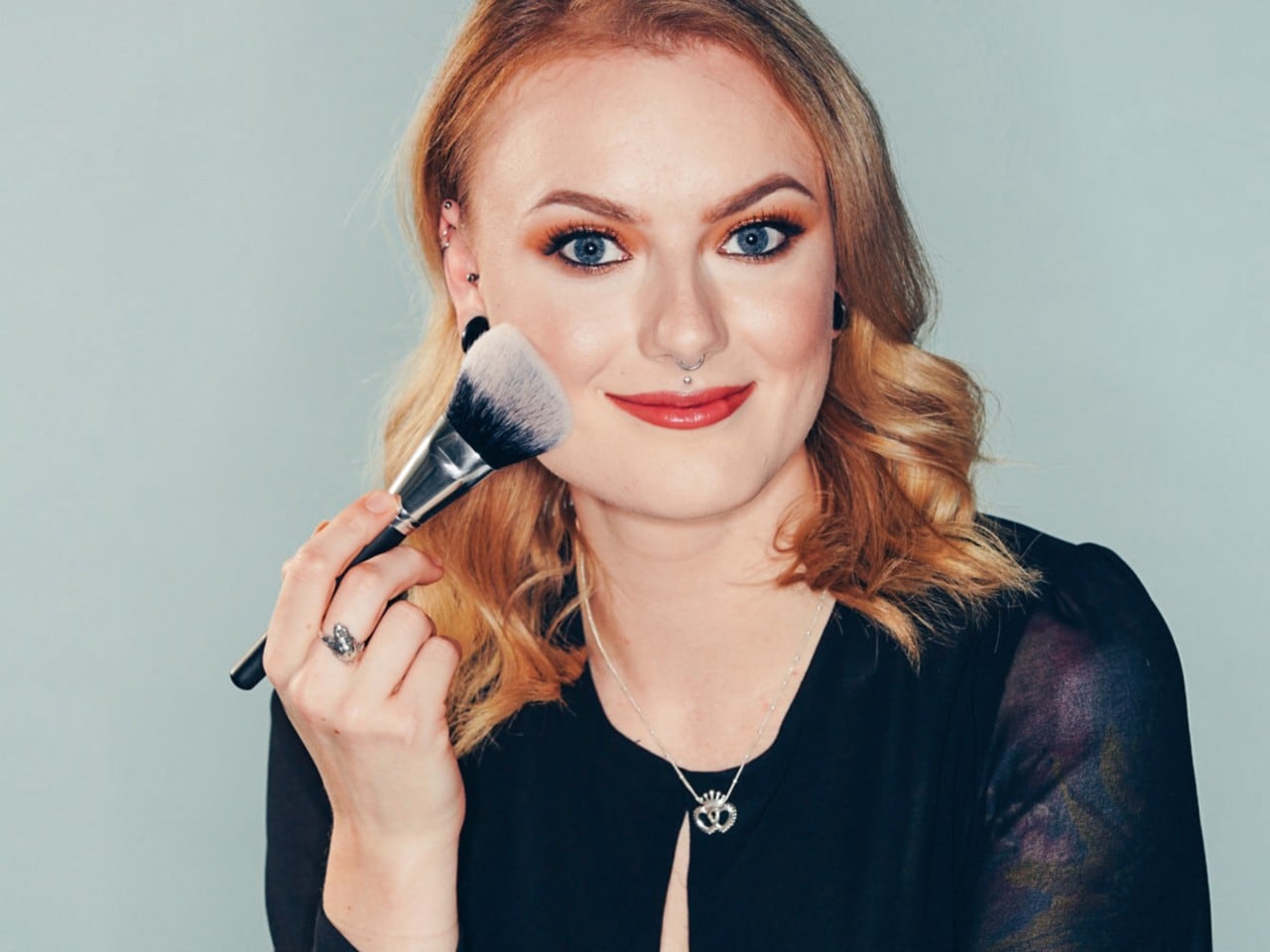 Blonde woman using makeup brush