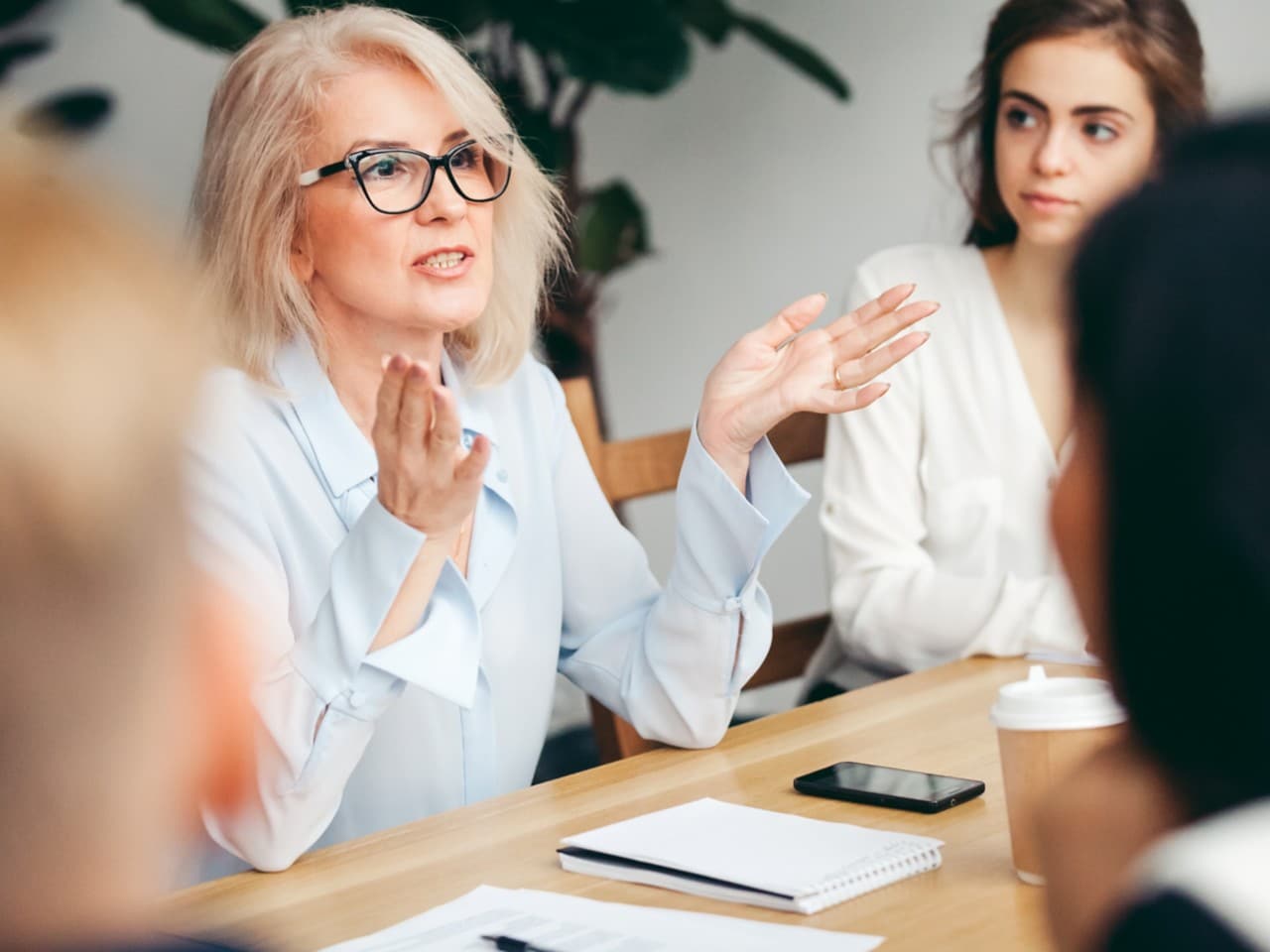 Des femmes en réunion qui écrivent sur un tableau blanc